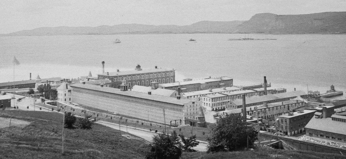 A picture of Sing Sing Prison with the Hudson River in the background